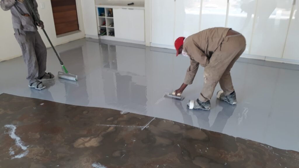 Applying epoxy coating on a house garage floor.