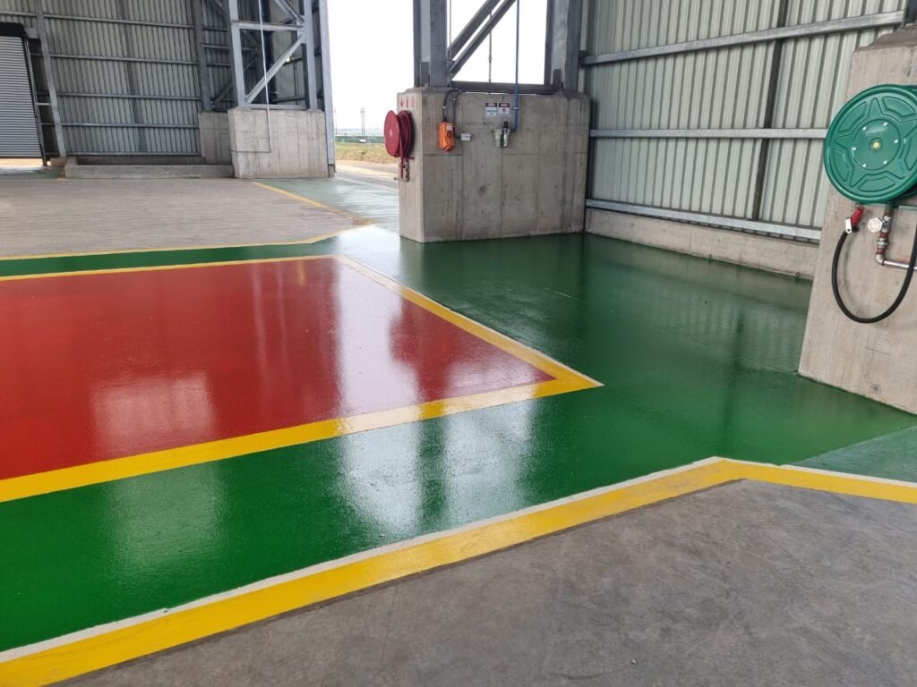 A hangar interior with a newly applied epoxy floor coating by APR Waterproofing, showcasing a sleek and durable finish