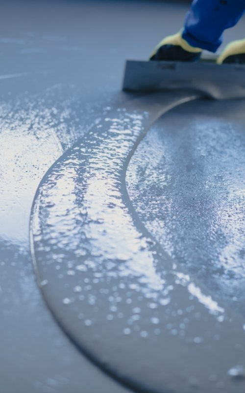 APR Waterproofing applying epoxy resin on an indoor floor to create a sleek and durable finish.